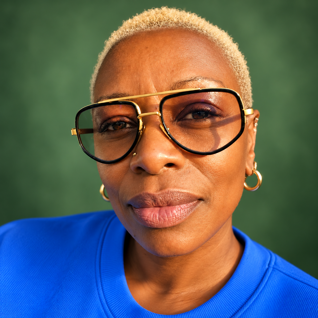 IamIngrid wearing gold-rimmed glasses and a blue top